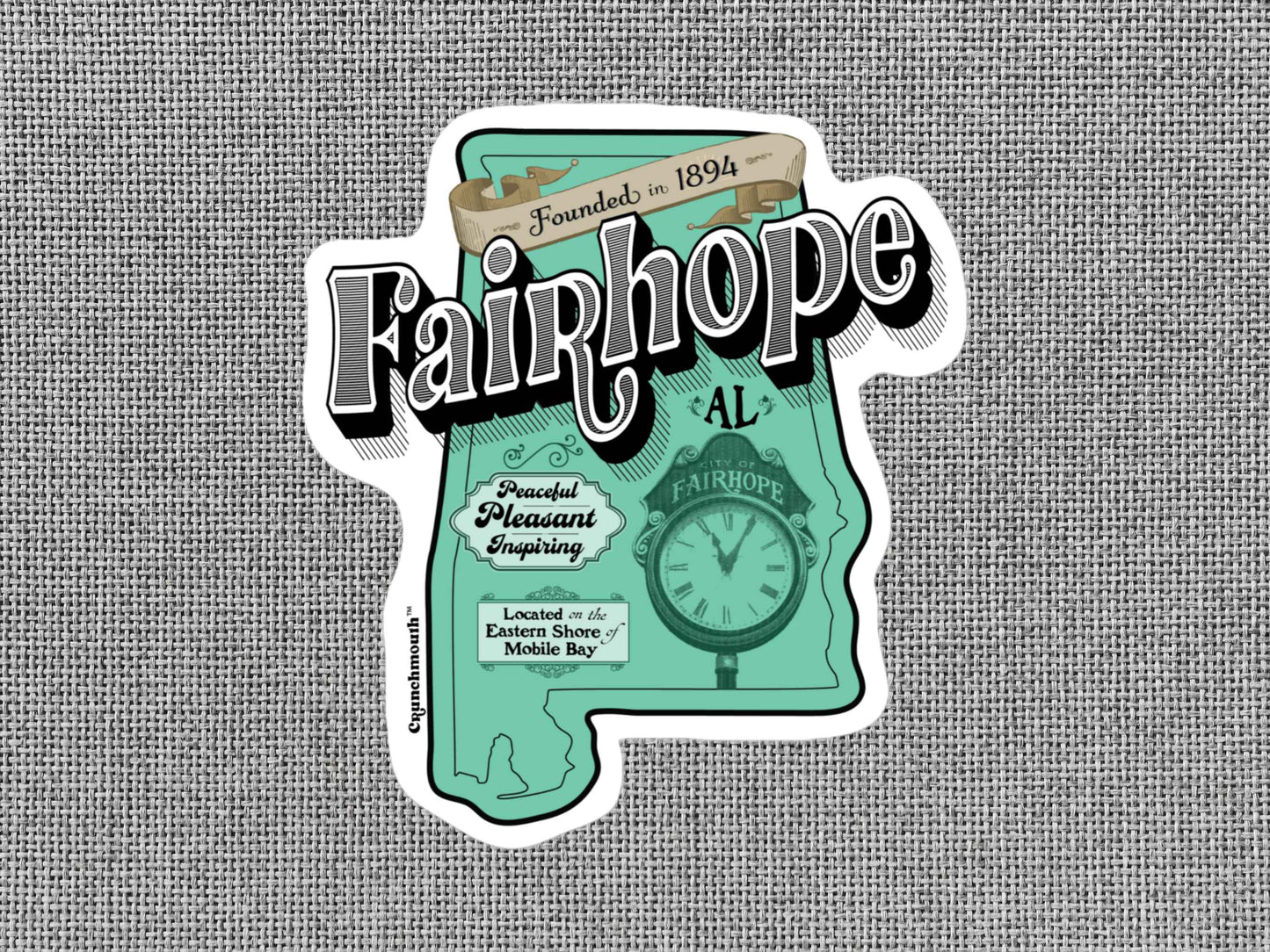 fairhope sticker, hand display, gray textured background