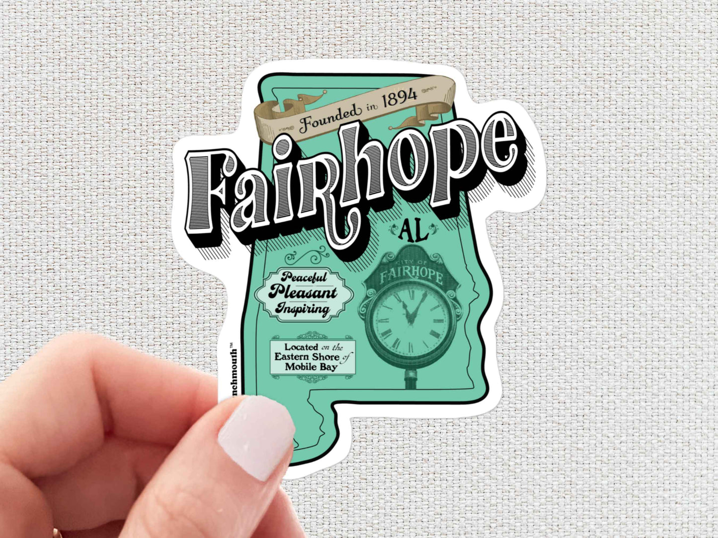 fairhope sticker, hand display, white textured background