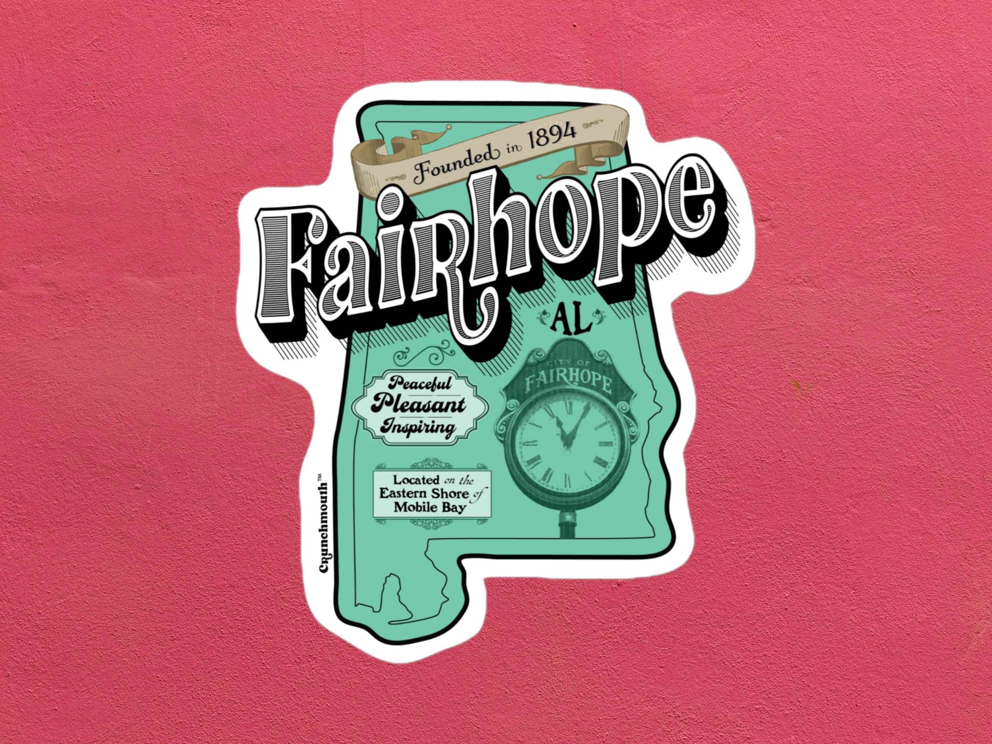 fairhope sticker, hand display, rose color textured background