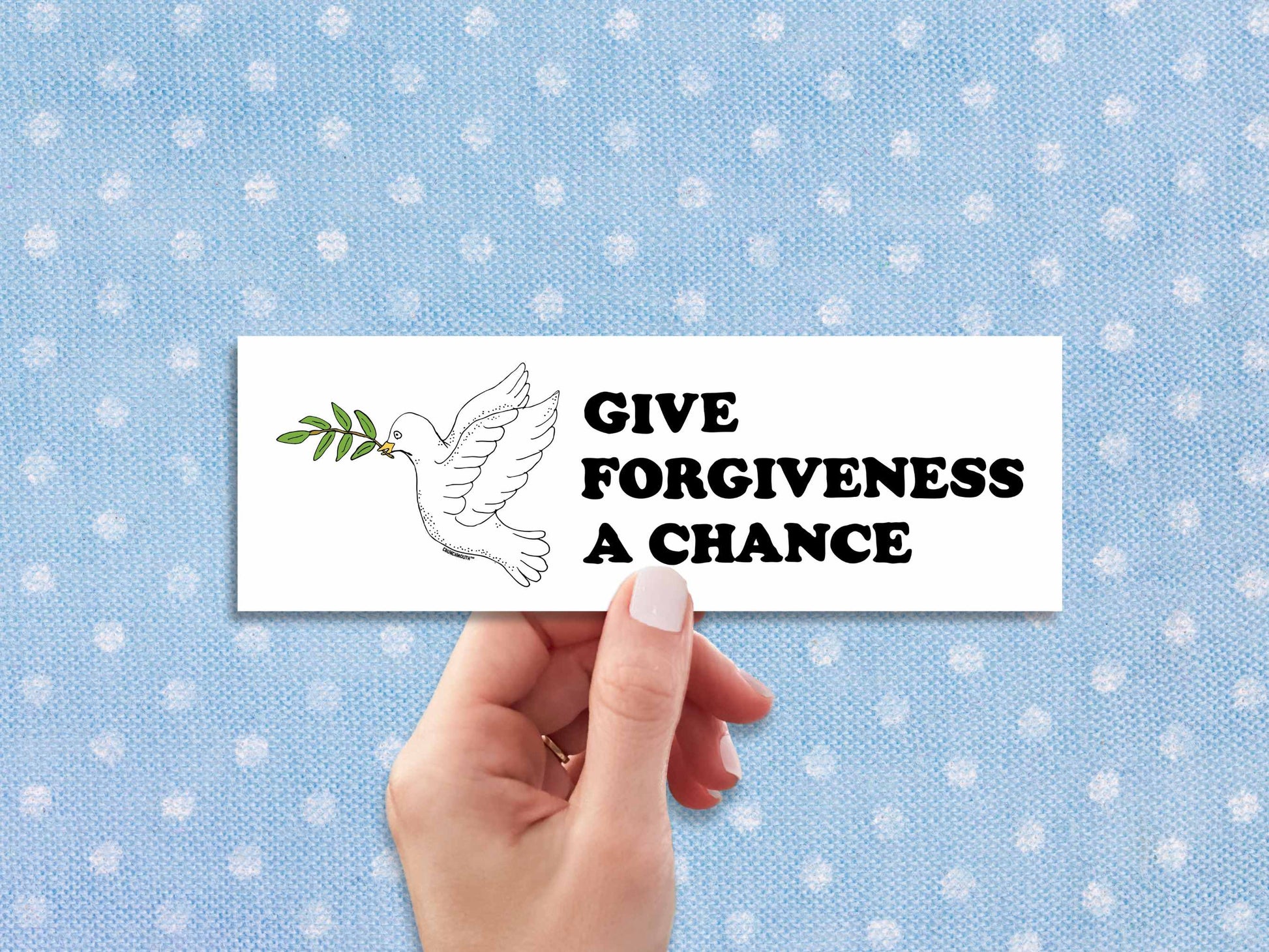give forgiveness a chance bumper sticker, hand display, polka dot fabric background