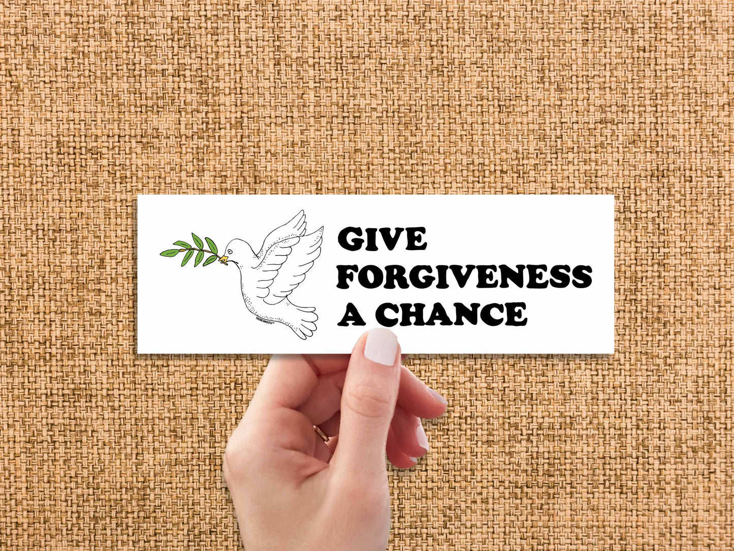 give forgiveness a chance bumper sticker, hand display, brown textured fabric background