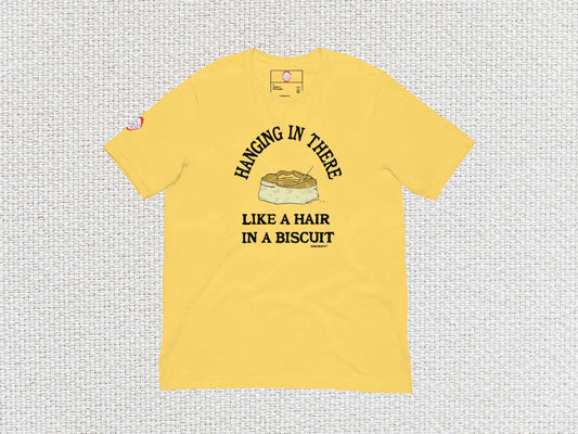 hanging in there like a hair in a biscuit shirt, funny t-shirts, flat, front, white textured background