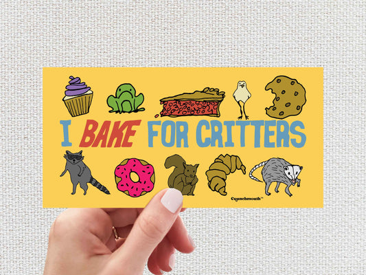 i bake for critters funny bumper sticker, hand display, white textured background