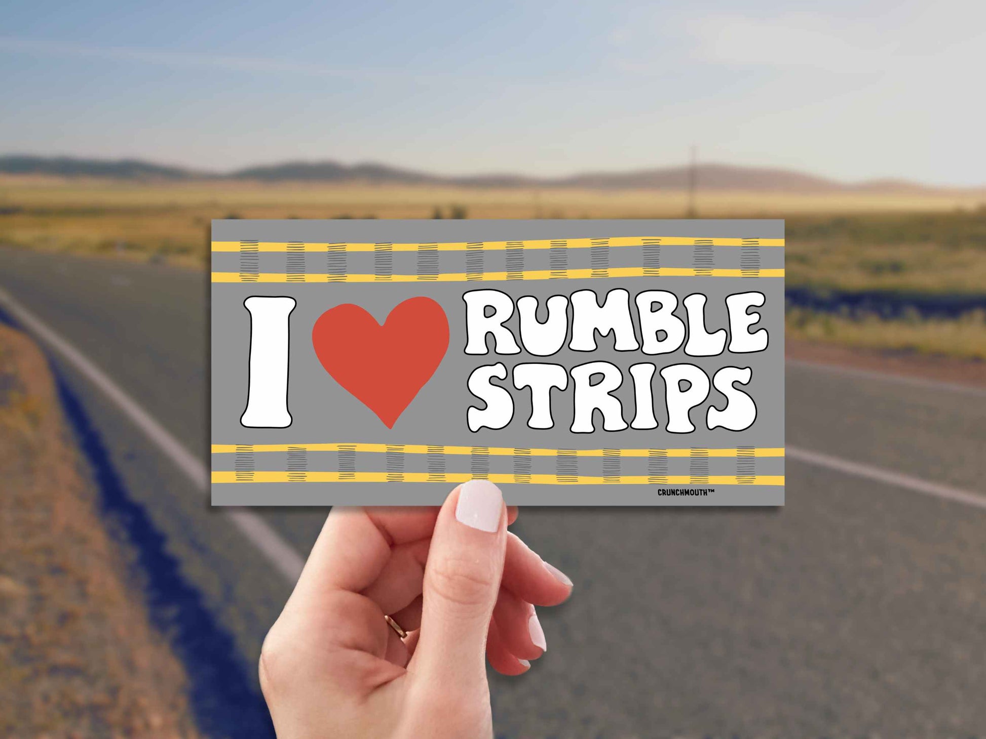 i love rumble strips bumper sticker, hand display, rural highway background