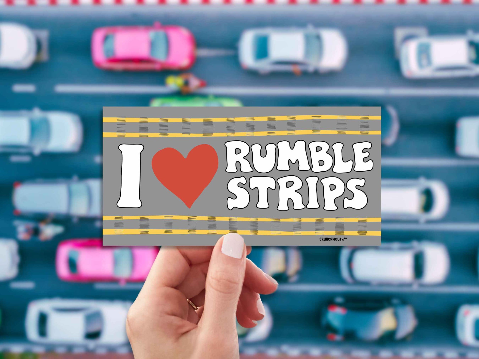 i love rumble strips bumper sticker, hand display, overhead view of traffic background