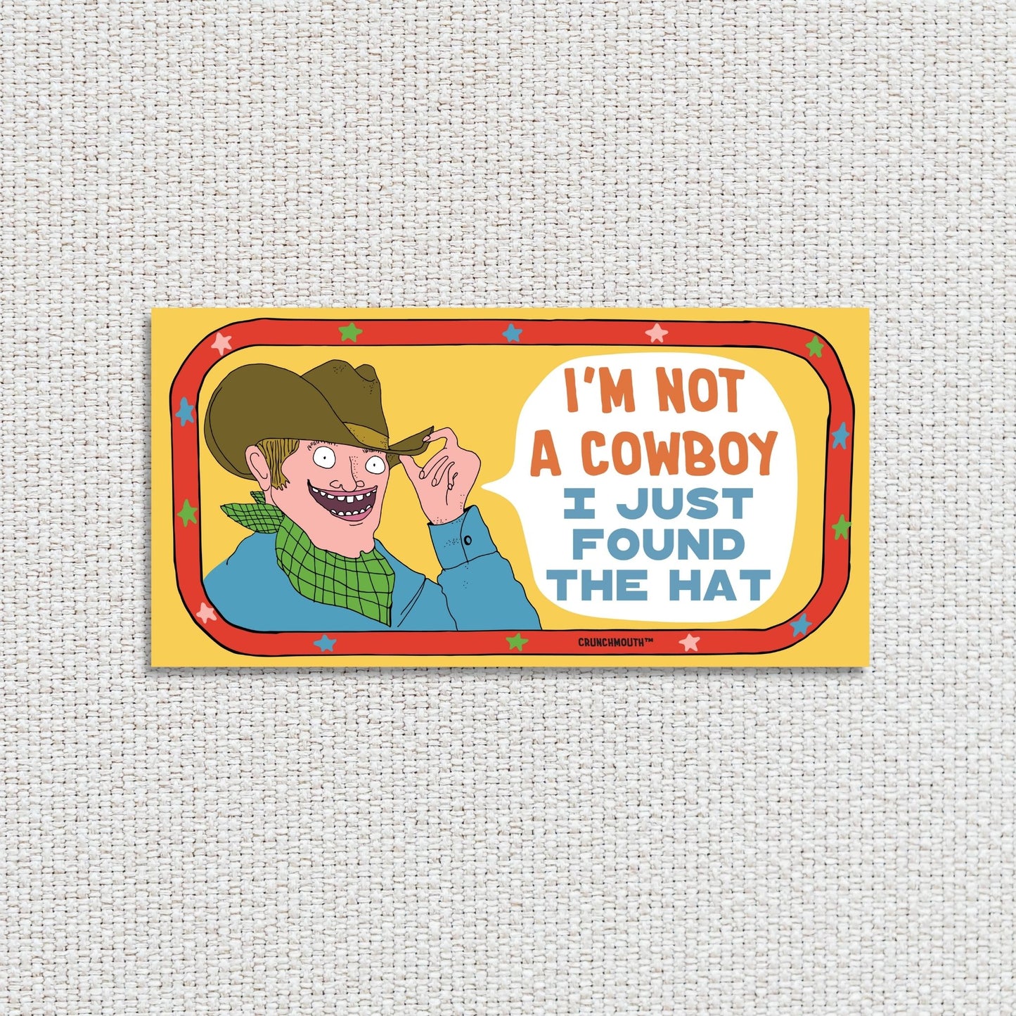 i'm not a cowboy (I just found the hat) funny western-themed bumper sticker, textured fabric background