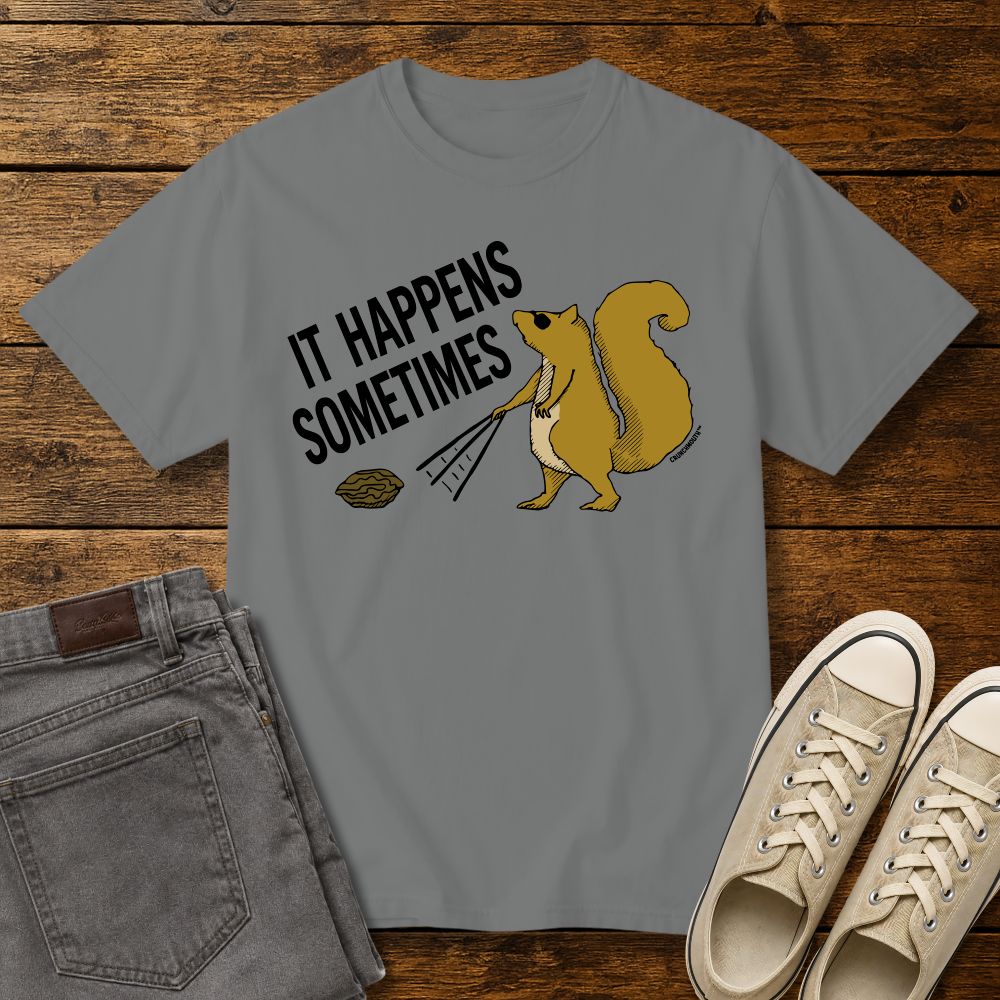 Funny squirrel graphic t-shirt on grey color tee with ‘It Happens Sometimes’ text, shown in flat lay mockup with jeans and sneakers on rustic wood background