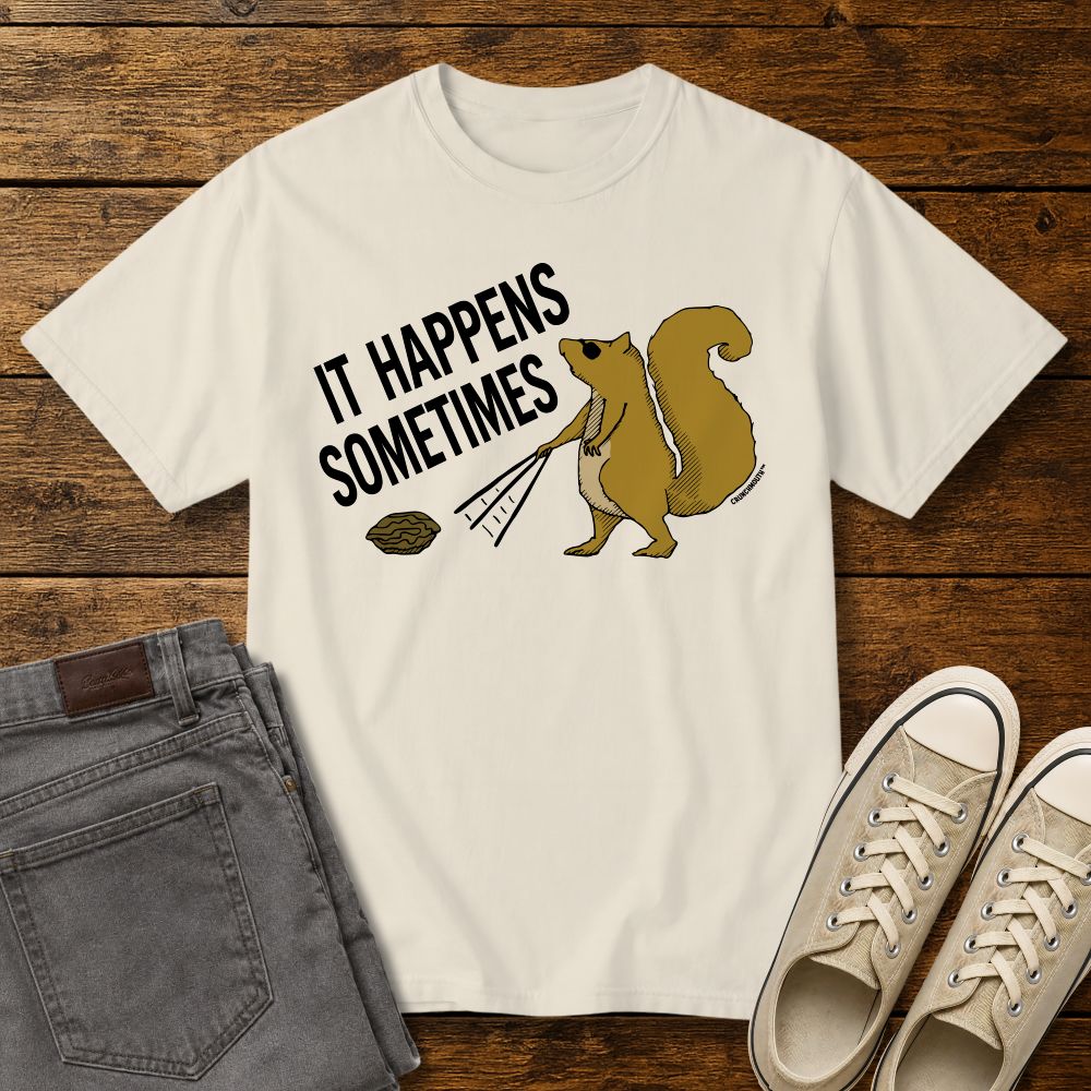 Funny squirrel graphic t-shirt on ivory color tee with ‘It Happens Sometimes’ text, shown in flat lay mockup with jeans and sneakers on rustic wood background