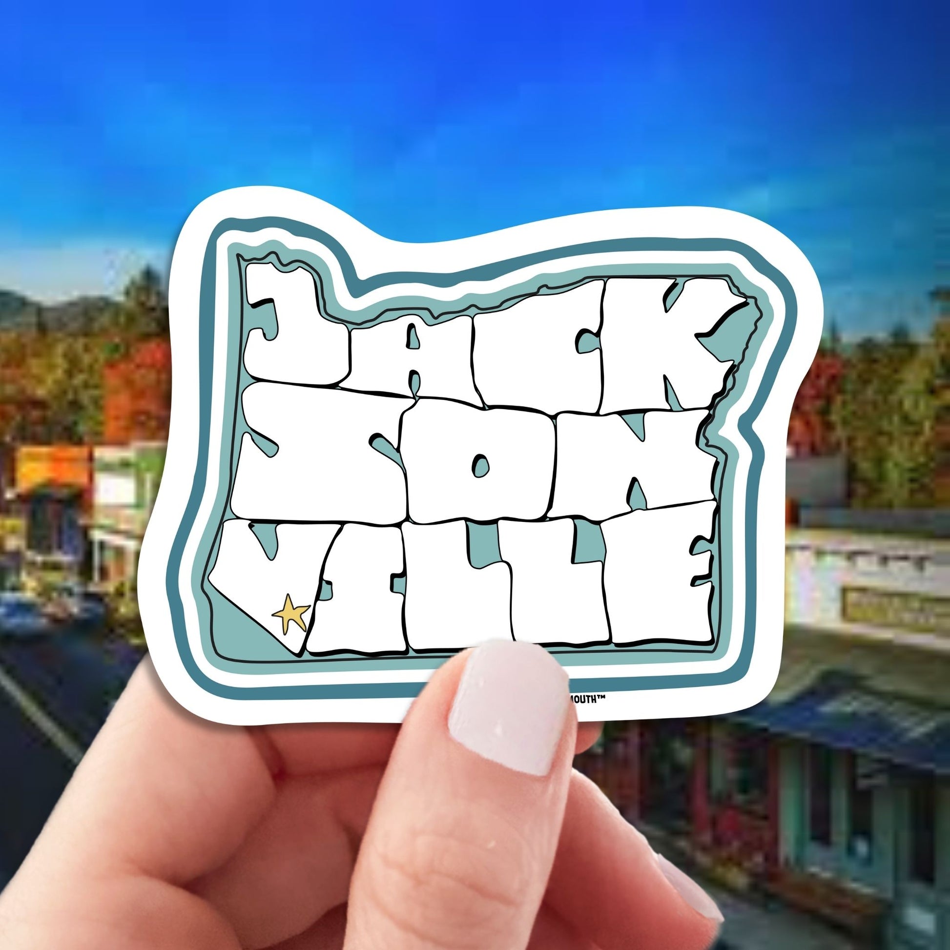 Jacksonville oregon travel luggage sticker, hand display, Jacksonville main street background
