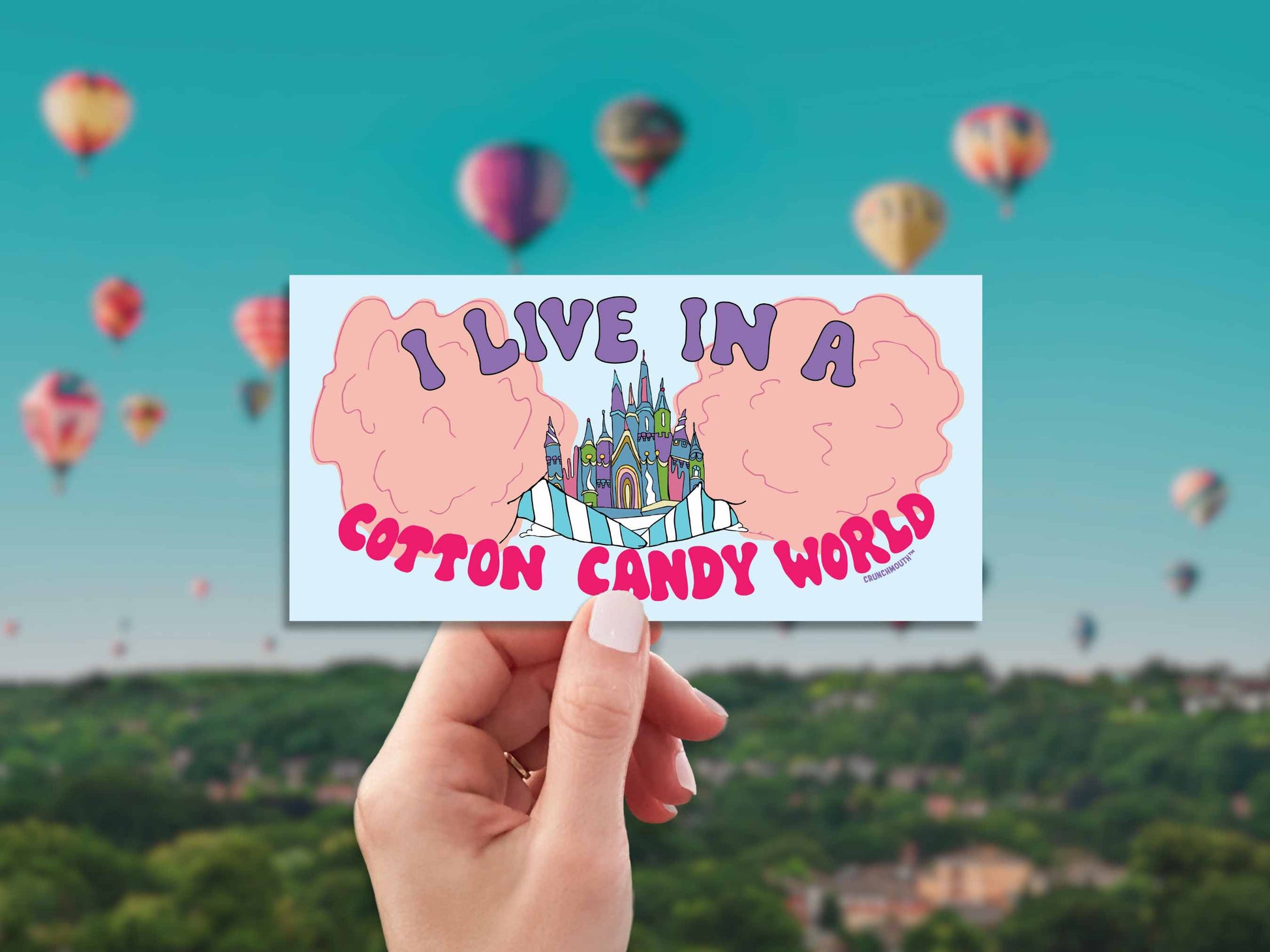 i live in a cotton candy world bumper sticker, hand display, hot air balloons background