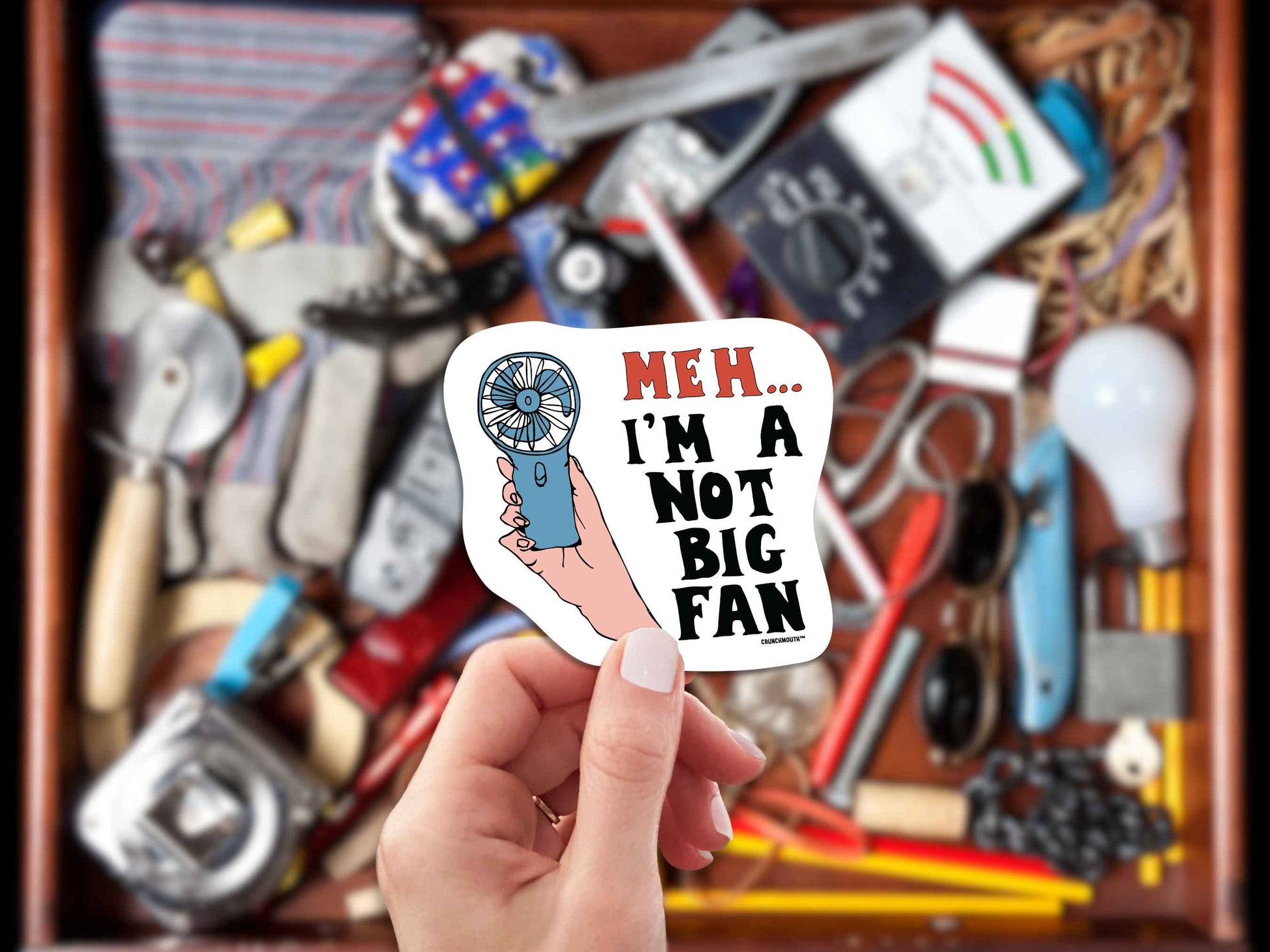 meh...i'm not a big fan sticker, hand display, junk drawer background