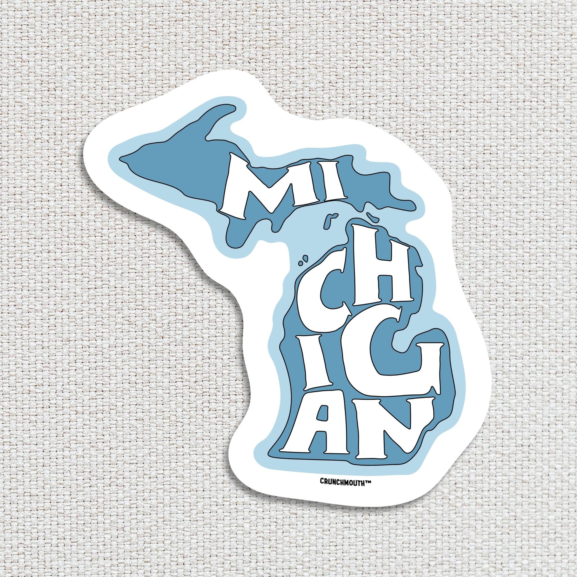 state of Michigan travel luggage sticker, textured fabric background
