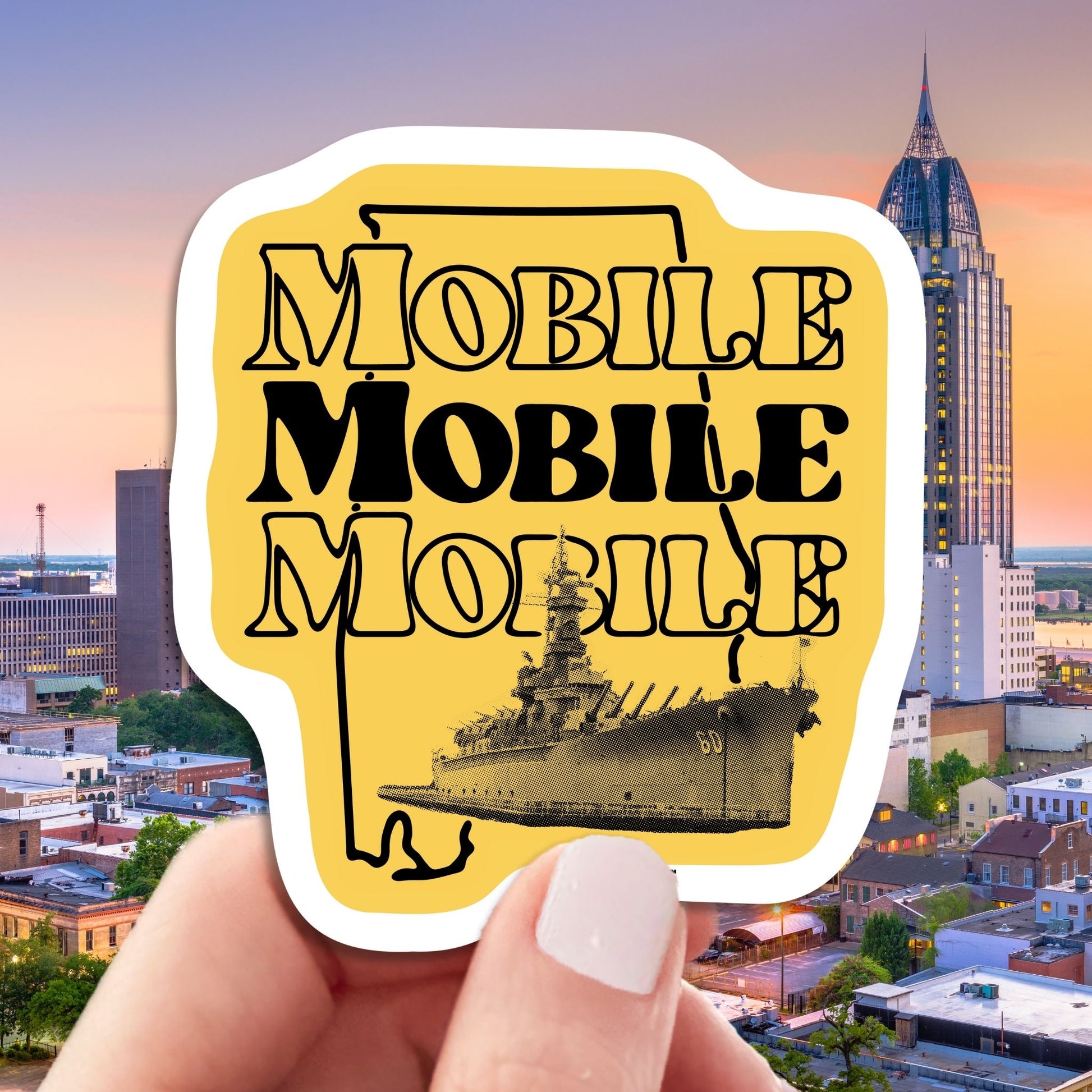mobile alabama travel luggage sticker featuring uss alabama battleship, hand display, cityscape background