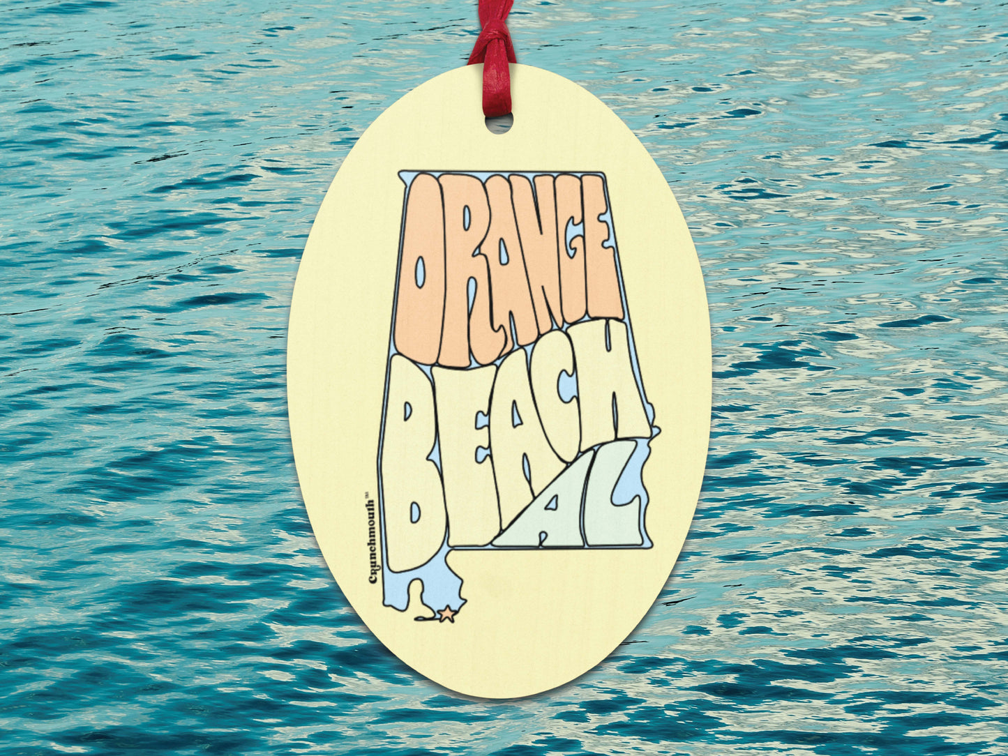 orange beach wooden Christmas ornament, front, blue ocean water background