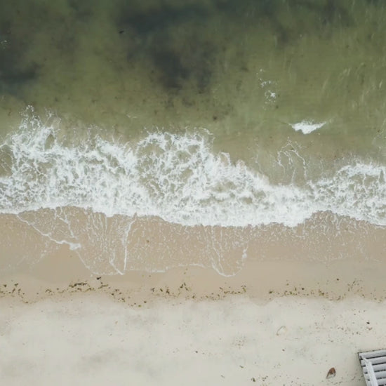 Nantucket island travel luggage sticker, hand display, ocean shore background