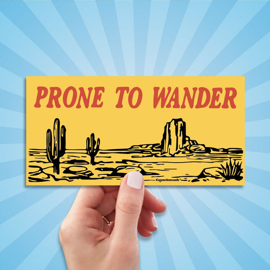 desert adventure bumper sticker, prone to wander, hand display, sun rays design background