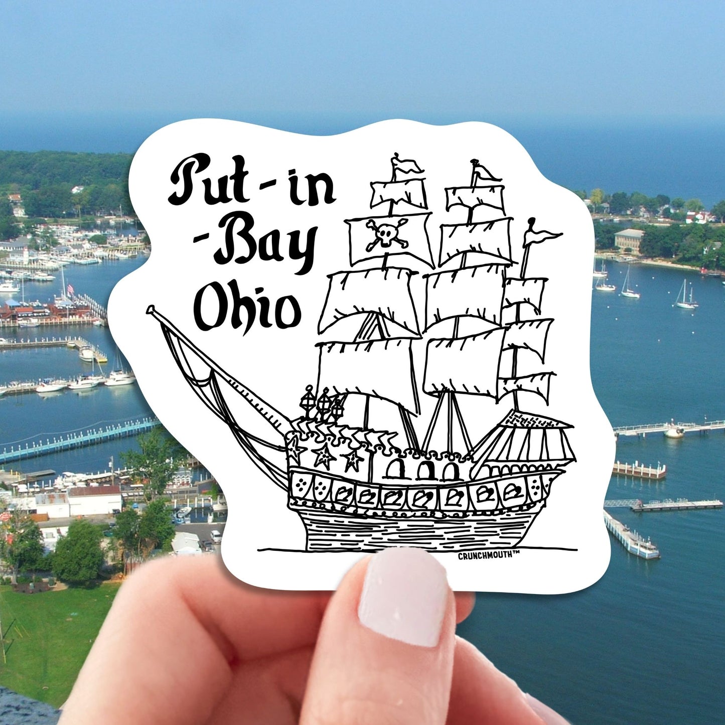 put-in-bay pirate ship travel luggage sticker, hand display, aerial view of town background
