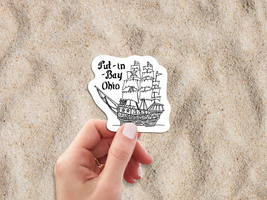 put-in-bay pirate ship travel luggage sticker, hand display, beach sand background