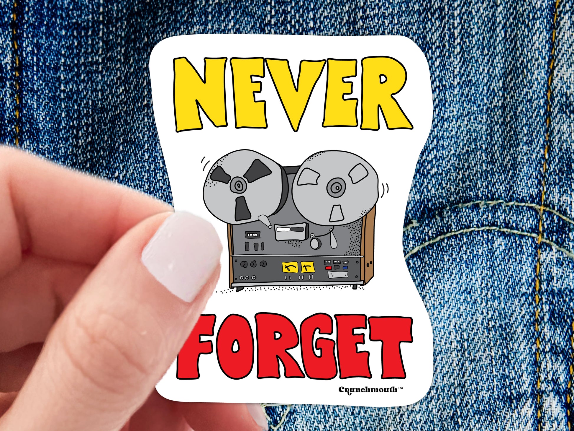 never forget reel to reel player sticker, hand display, blue jeans background