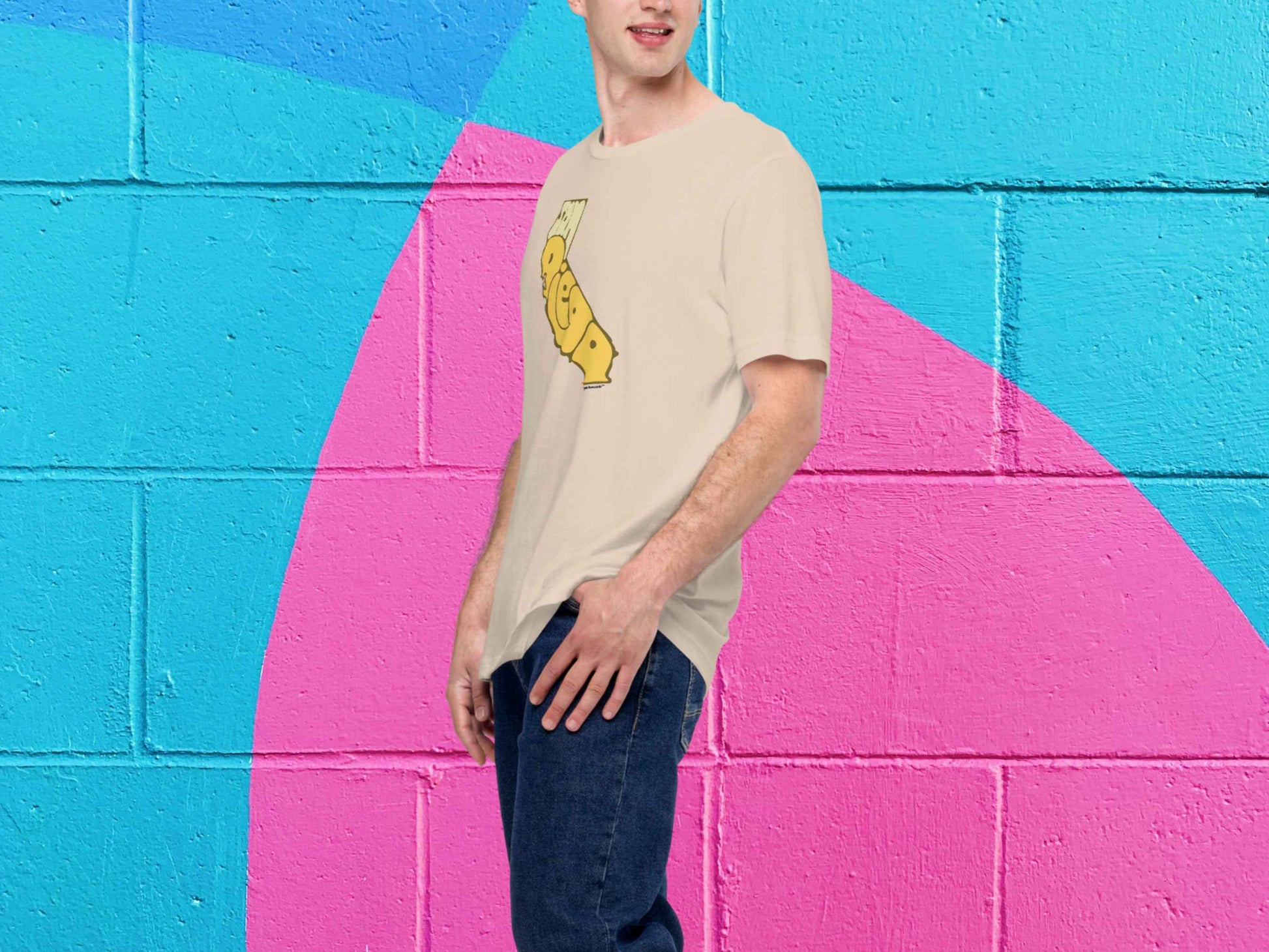 san diego shirt, retro t shirts, male model, front left, vibrant color cinder block wall background