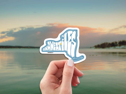 skaneateles travel luggage sticker, hand display, lake background