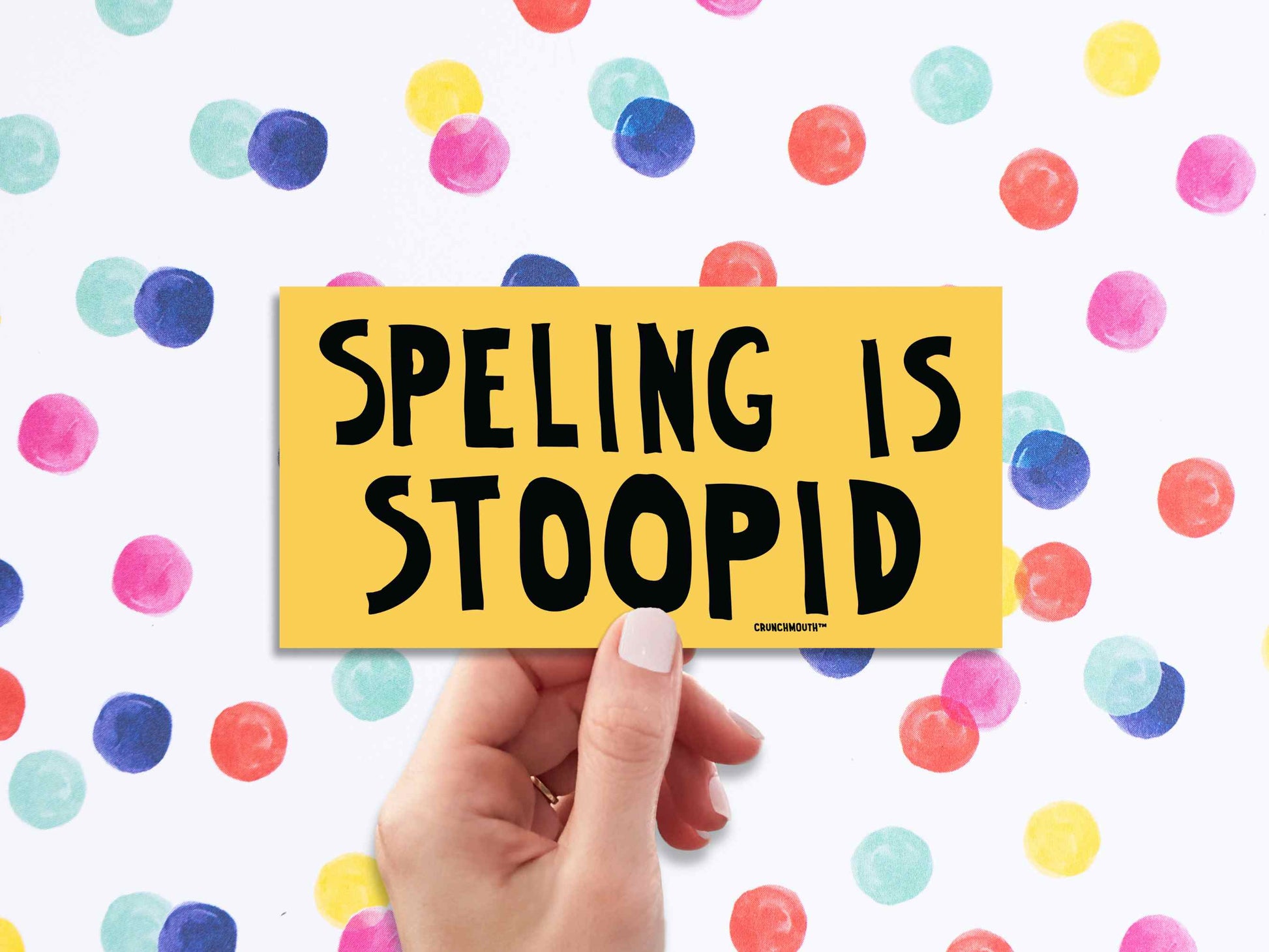 spelling is stupid funny bumper sticker, hand display, colorful polka dots background
