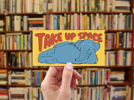 take up space elephant bumper sticker, hand display, bookshelf background