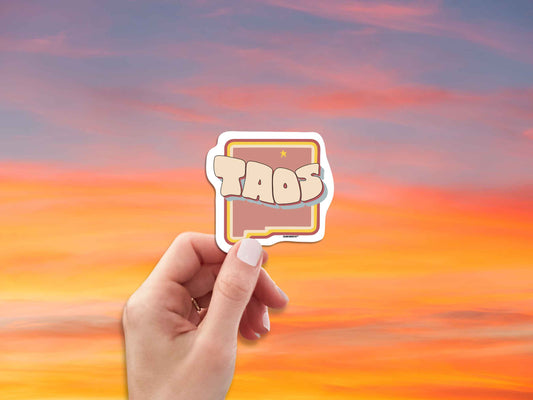 taos travel luggage sticker, hand display, red sky background