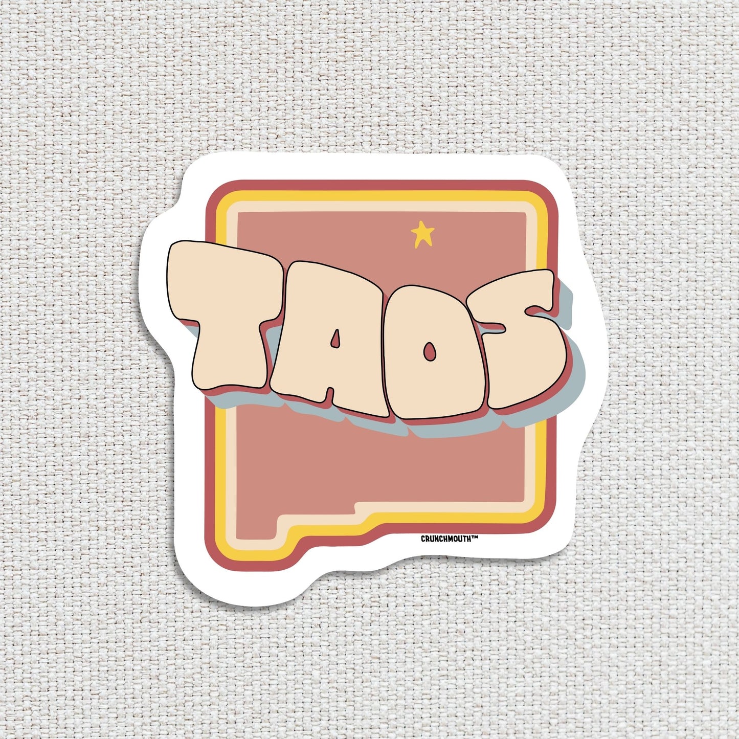 taos new mexico travel luggage sticker, hand display, textured fabric background
