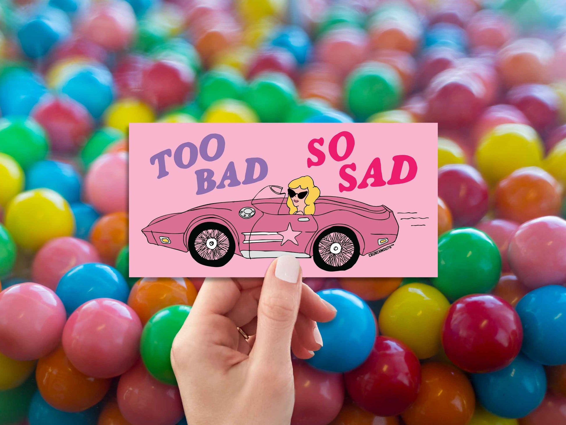 too bad so sad bumper sticker, hand display, bubble gum background