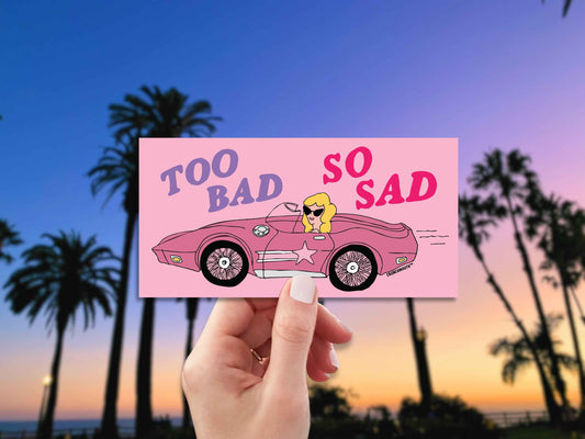 too bad so sad bumper sticker, hand display, malibu palm tree background