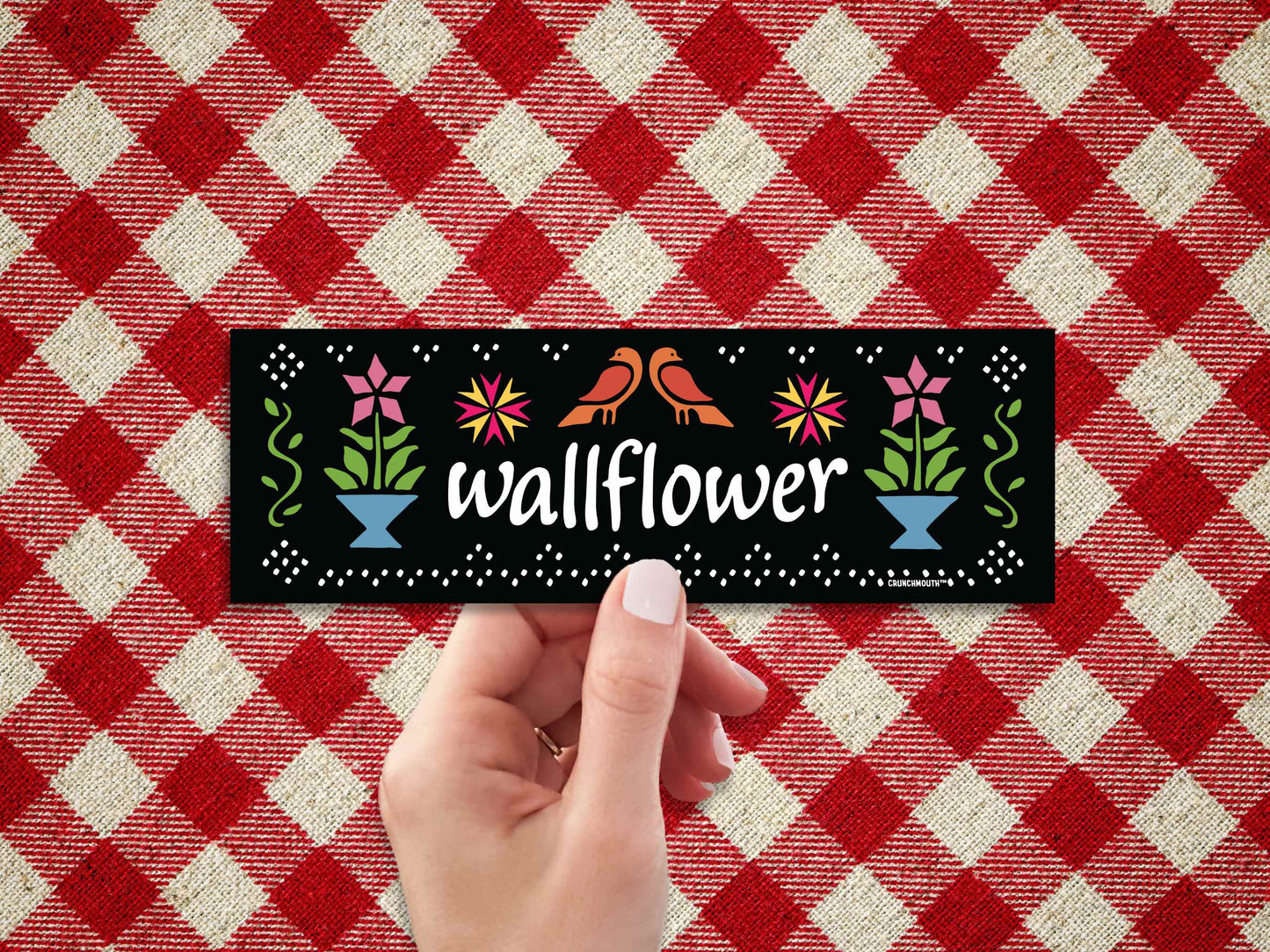 wallflower bumper sticker, hand display, red plaid fabric background