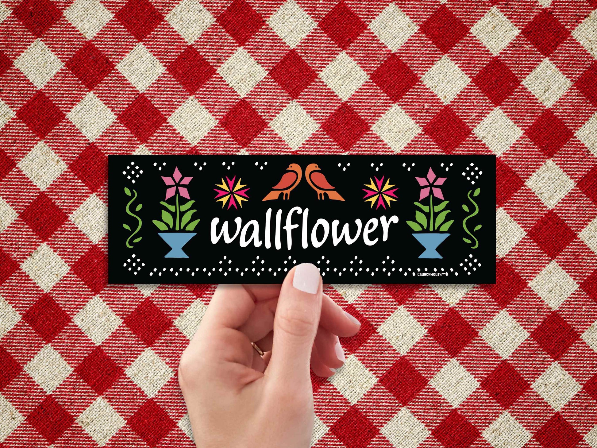 wallflower bumper sticker, hand display, red plaid fabric background