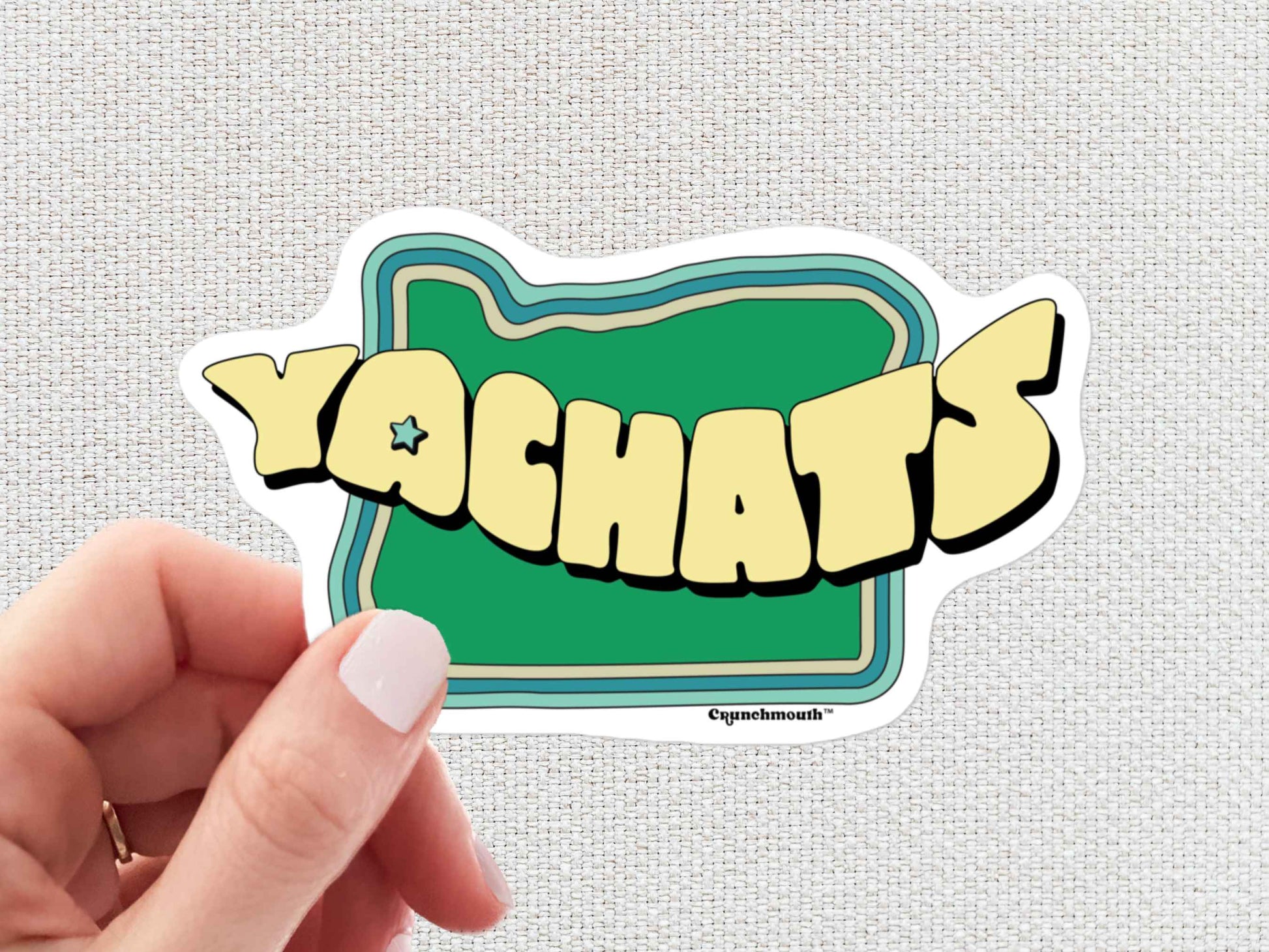 yachats sticker, hand display, white textured background