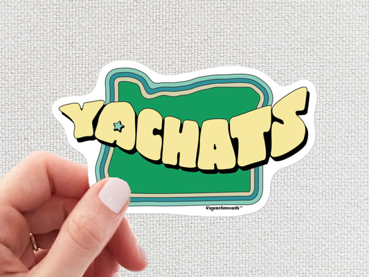 yachats sticker, hand display, white textured background