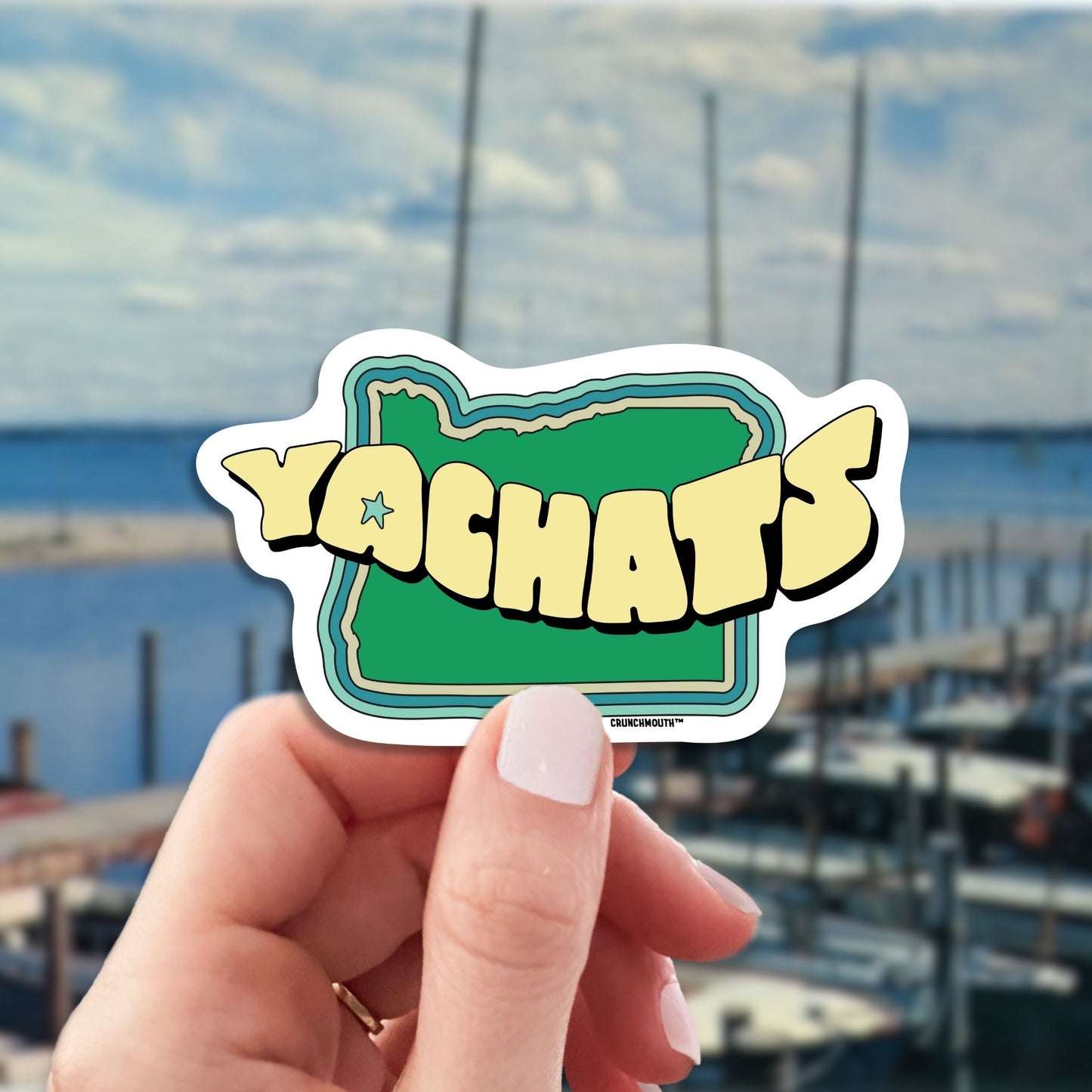yachats travel luggage sticker, hand display, sailboats background